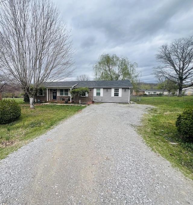 single story home with driveway and a porch