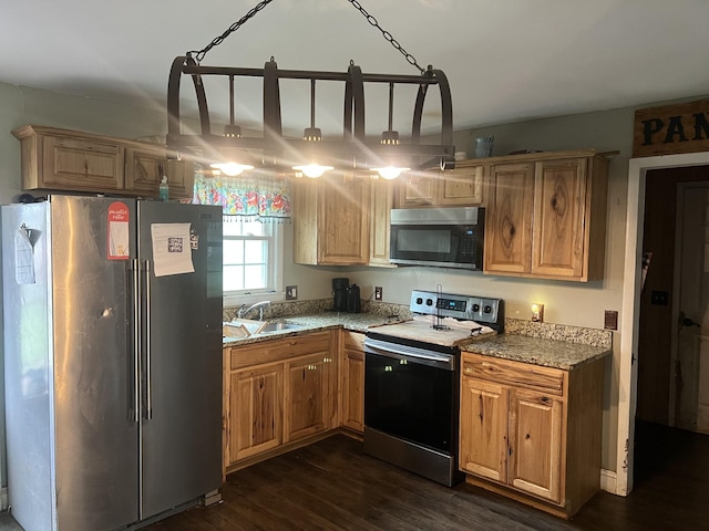 kitchen featuring dark wood-type flooring, light stone countertops, a sink, and stainless steel appliances
