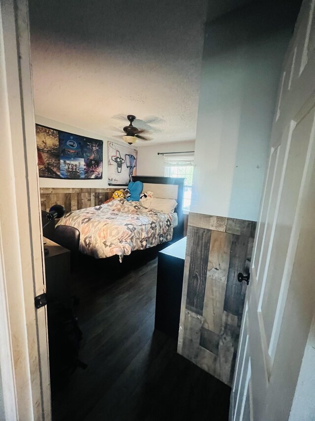 bedroom with wood finished floors, ceiling fan, and a textured ceiling