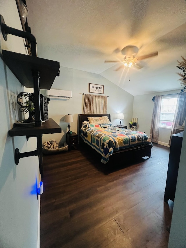 bedroom with an AC wall unit, lofted ceiling, a textured ceiling, and wood finished floors