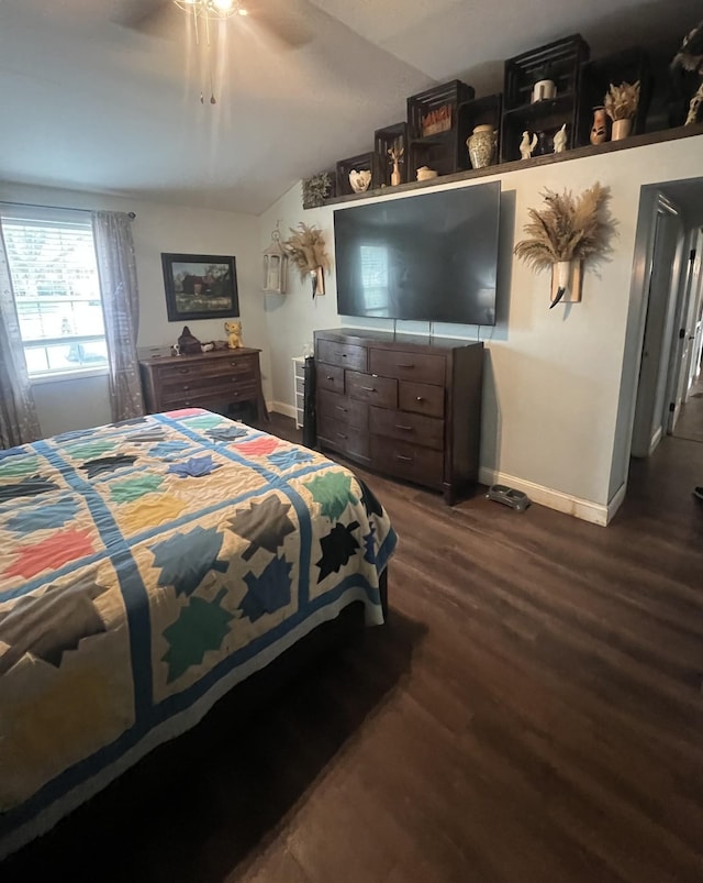 bedroom with baseboards, vaulted ceiling, wood finished floors, and a ceiling fan