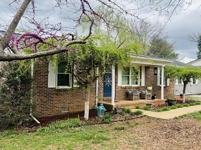 view of front of home with a porch and brick siding