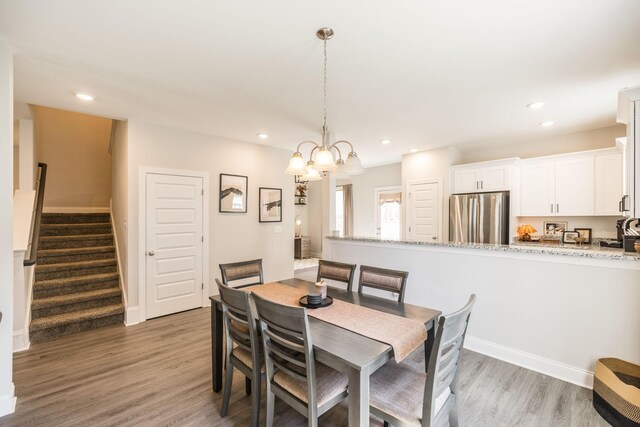 dining room with stairs, light wood-type flooring, recessed lighting, and a chandelier