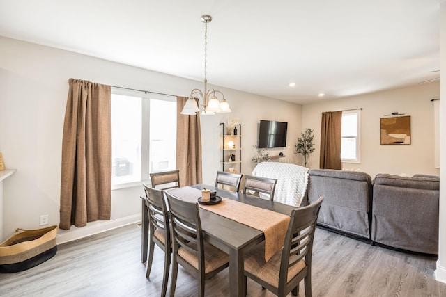 dining area with light wood finished floors, baseboards, recessed lighting, and an inviting chandelier