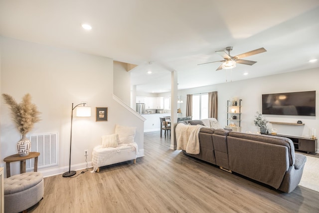 living area with light wood-type flooring, baseboards, visible vents, ceiling fan, and recessed lighting
