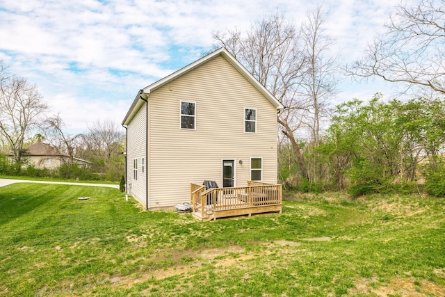 rear view of house featuring a deck and a yard