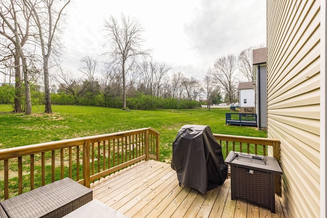 wooden deck with grilling area and a lawn