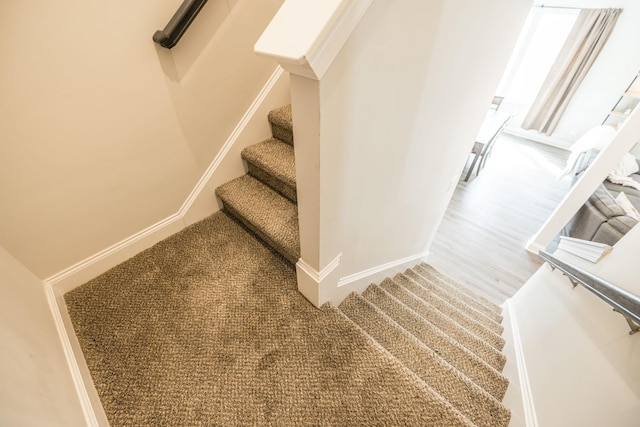 staircase with baseboards and carpet