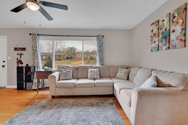 living room with baseboards, wood finished floors, and a ceiling fan