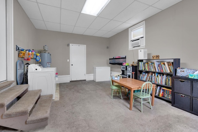 interior space with water heater, carpet flooring, a drop ceiling, and separate washer and dryer