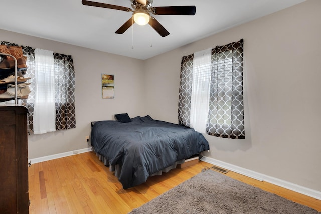 bedroom featuring baseboards, ceiling fan, and wood finished floors