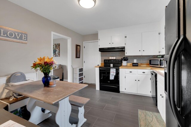 kitchen with light countertops, under cabinet range hood, decorative backsplash, white cabinets, and black appliances