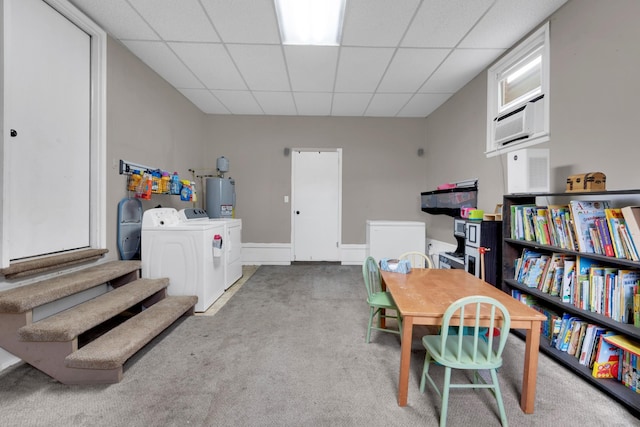 interior space featuring water heater, washing machine and clothes dryer, carpet flooring, and a paneled ceiling
