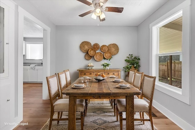 dining area featuring a ceiling fan, baseboards, and wood finished floors