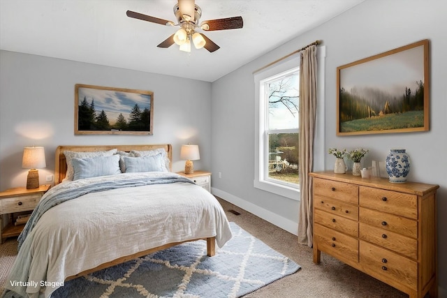 carpeted bedroom featuring baseboards and a ceiling fan