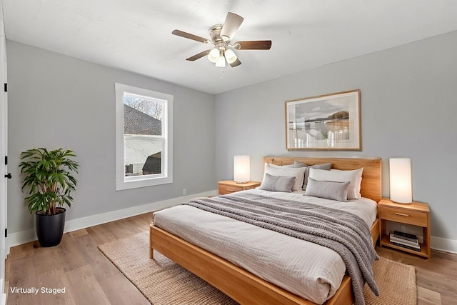 bedroom featuring light wood finished floors, baseboards, and a ceiling fan