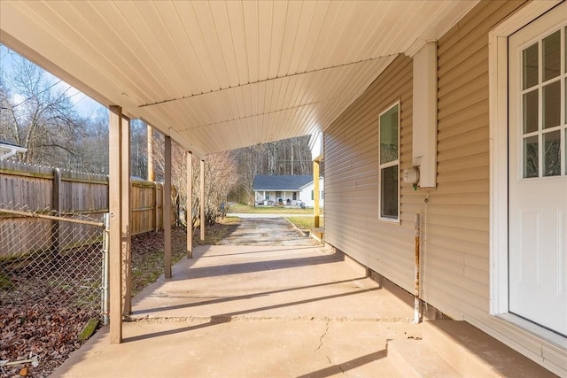 view of patio / terrace featuring an attached carport and fence