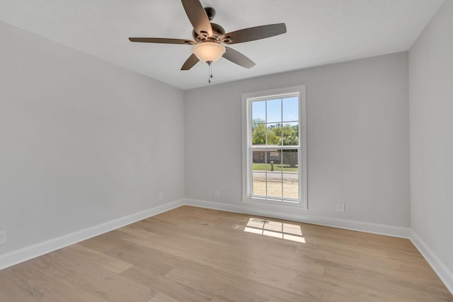 empty room with light wood-type flooring, baseboards, and a ceiling fan