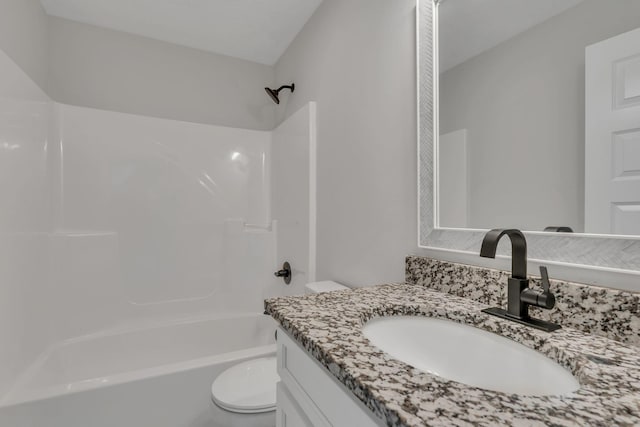 bathroom with washtub / shower combination, vanity, and toilet