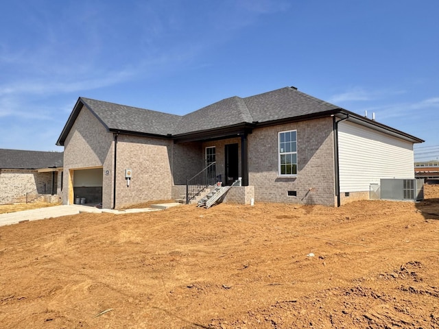 back of property with brick siding, crawl space, central air condition unit, and an attached garage