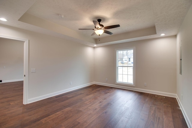 unfurnished room featuring a textured ceiling, baseboards, a raised ceiling, and a ceiling fan