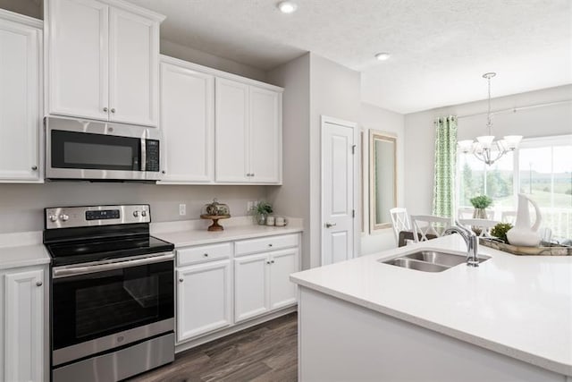 1169 Savannah Ave, Gallatin, TN 37066 - kitchen with appliances with stainless steel finishes, a sink, a chandelier, dark wood-type flooring, and white cabinetry