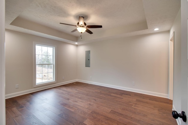unfurnished room featuring a tray ceiling, ceiling fan, baseboards, and a textured ceiling