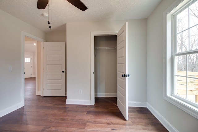 unfurnished bedroom featuring a closet, baseboards, wood finished floors, and a textured ceiling