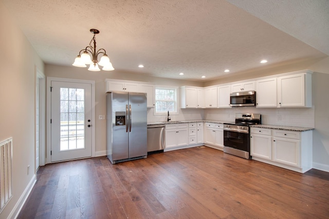 kitchen with white cabinets, dark wood-style flooring, a chandelier, recessed lighting, and stainless steel appliances