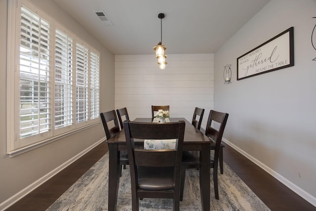 dining space featuring dark wood-type flooring, visible vents, baseboards, and a healthy amount of sunlight