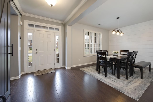 foyer entrance featuring a notable chandelier, baseboards, crown molding, and dark wood finished floors