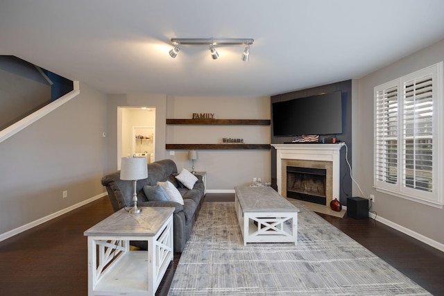 living room featuring wood finished floors, baseboards, and a tile fireplace