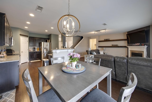 dining space with visible vents, a notable chandelier, a fireplace, dark wood finished floors, and recessed lighting