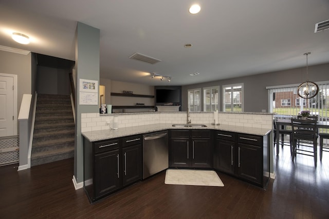 kitchen featuring a sink, decorative backsplash, and dishwasher