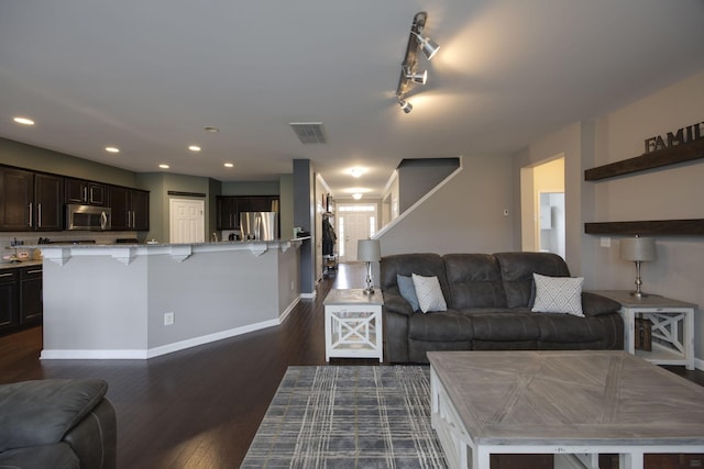 living area featuring recessed lighting, visible vents, dark wood-style flooring, and baseboards