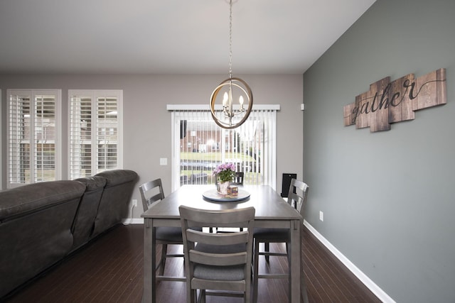 dining area featuring dark wood-style floors, baseboards, and an inviting chandelier