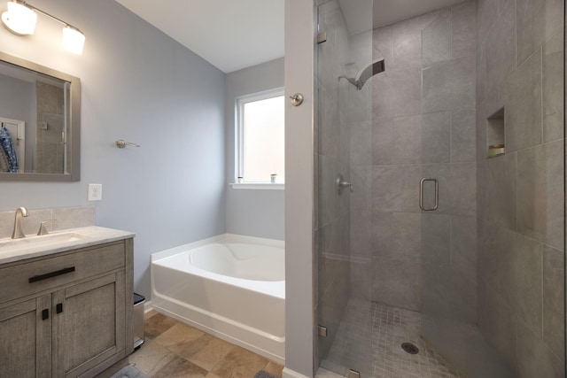 bathroom with a stall shower, a garden tub, and vanity