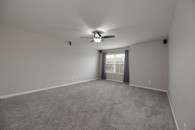 unfurnished room featuring carpet floors, ceiling fan, and baseboards