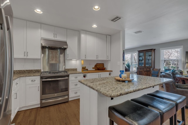 4337 Morriswood Dr, Nashville, TN 37204 - kitchen with stainless steel appliances, range hood, white cabinetry, dark wood-style flooring, and recessed lighting