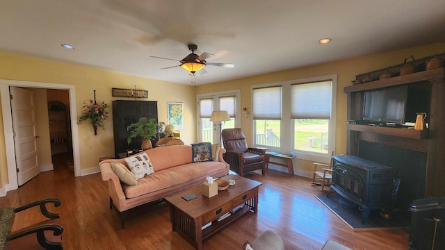 1385 Mitchell St, Celina, TN 38551 - living room with baseboards, ceiling fan, wood finished floors, and a wood stove