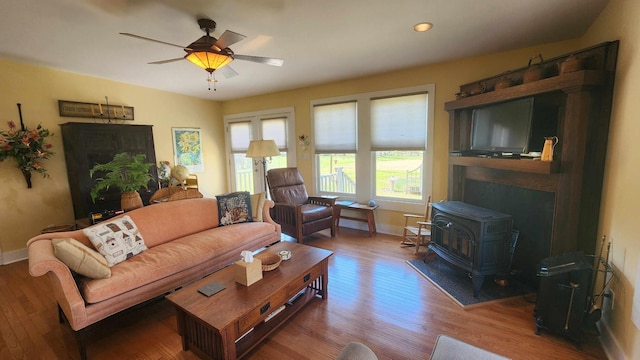 1385 Mitchell St, Celina, TN 38551 - living area featuring baseboards, ceiling fan, wood finished floors, recessed lighting, and a wood stove