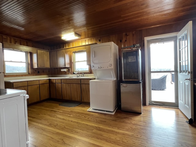 764 Cedar Hill Rd, Celina, TN 38551 - kitchen featuring wooden ceiling, stacked washer / dryer, wooden walls, light wood-style flooring, and range