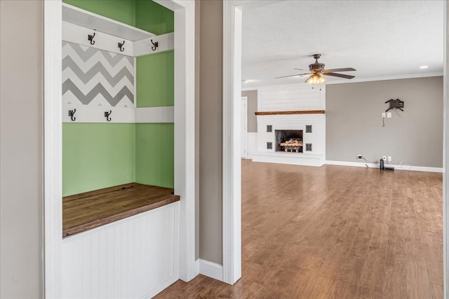 mudroom featuring wood finished floors, a textured ceiling, baseboards, and ceiling fan