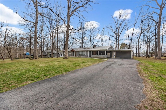 view of front of home with an attached carport, aphalt driveway, and a front yard