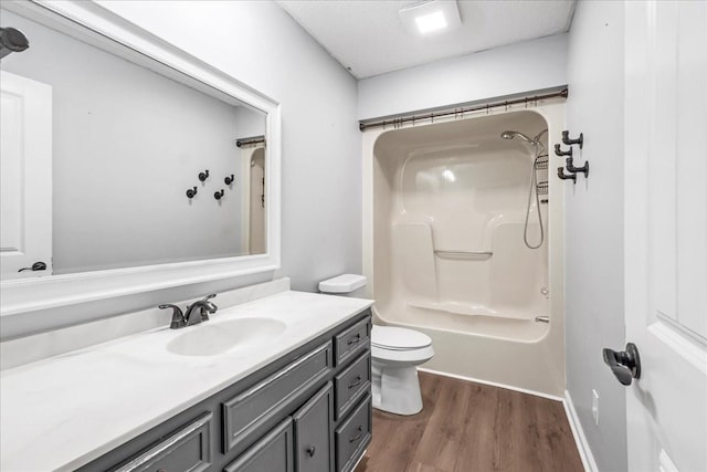 full bath featuring bathtub / shower combination, toilet, wood finished floors, and vanity