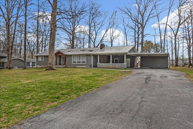 ranch-style house with a front yard, driveway, a carport, and a chimney