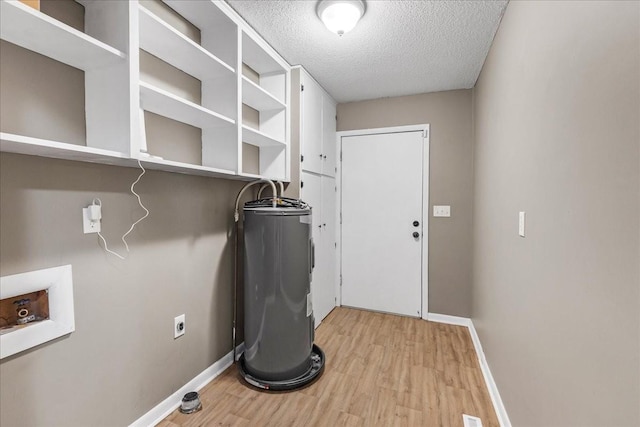 clothes washing area featuring water heater, light wood finished floors, a textured ceiling, laundry area, and baseboards