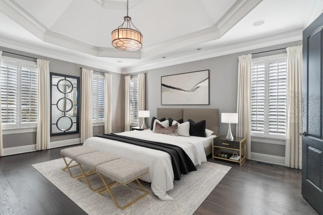 bedroom featuring baseboards, dark wood-style floors, a tray ceiling, and ornamental molding