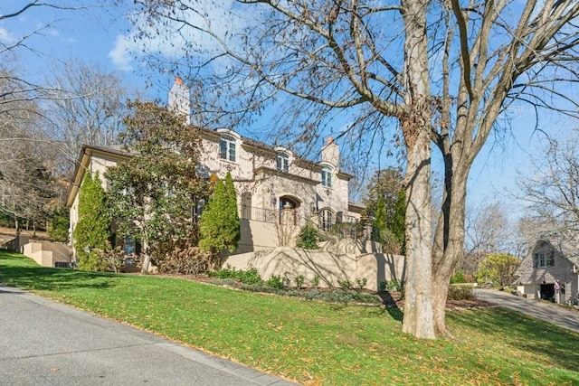 view of front of house with stucco siding and a front yard