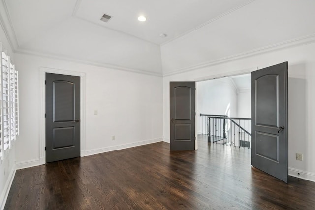 spare room with vaulted ceiling, dark wood-type flooring, baseboards, visible vents, and ornamental molding